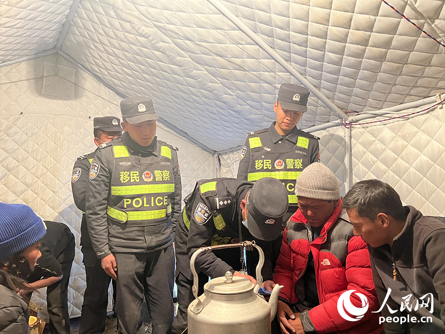 00后洛桑多吉（左）和馬樂聘（右）開展防火宣傳。人民日?qǐng)?bào)記者 瓊達(dá)卓嘎攝