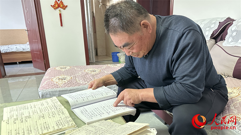 青格達(dá)湖鄉(xiāng)天山村村民李強(qiáng)拿出近幾年的賬本查看。人民網(wǎng)記者 楊睿攝